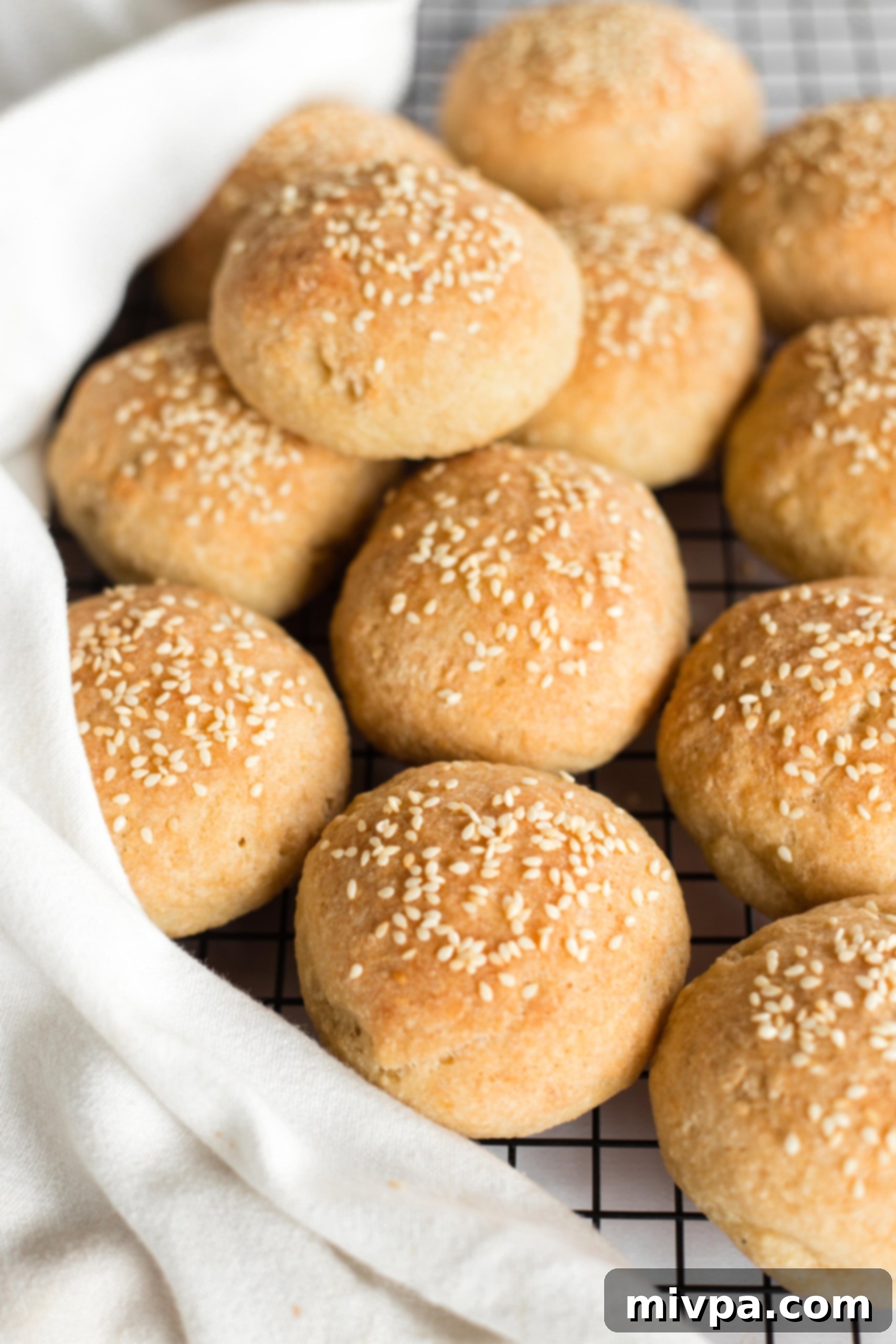 Gluten-free slider buns cooling on a wire rack after being removed from the pan.
