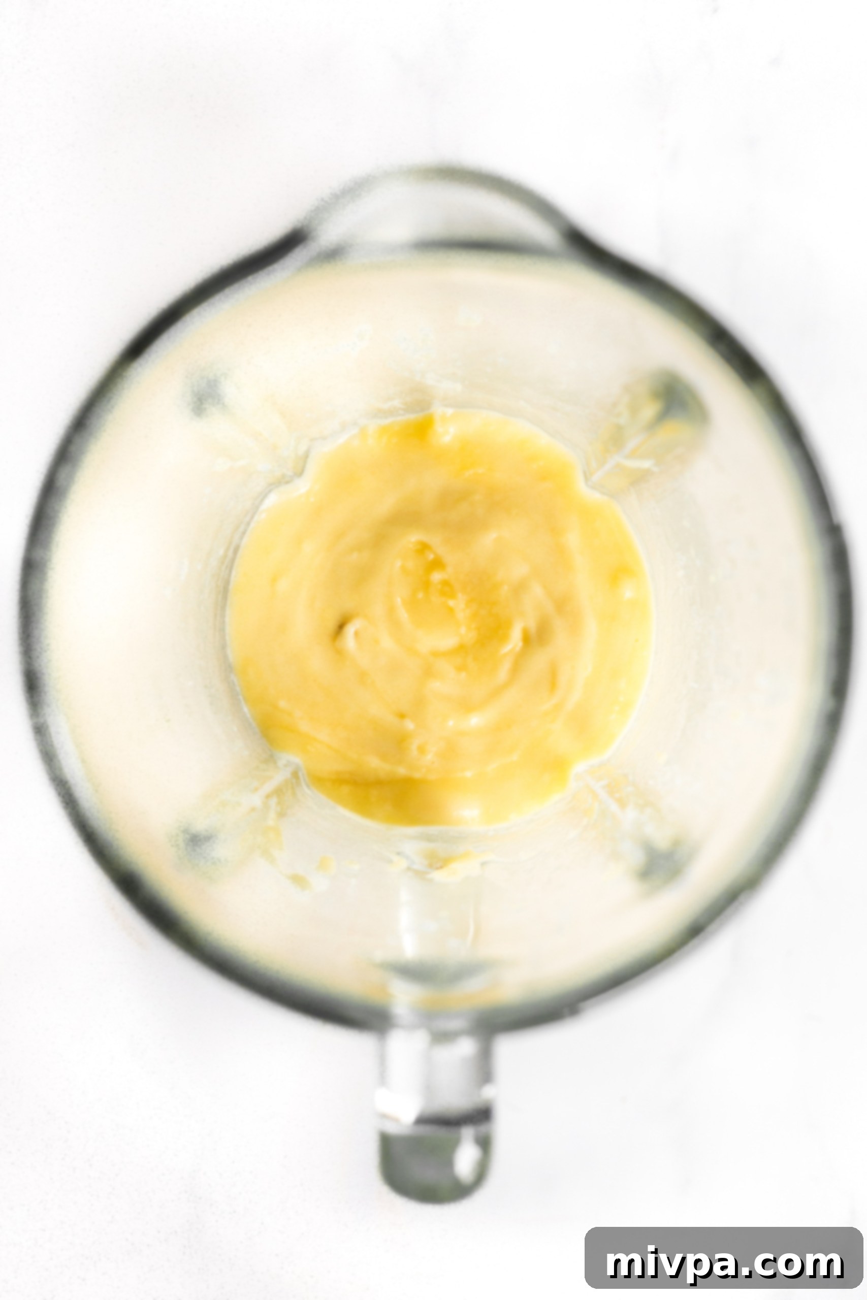 The smooth, processed yellow mixture of mashed potatoes and eggs in a high-speed blender bowl.