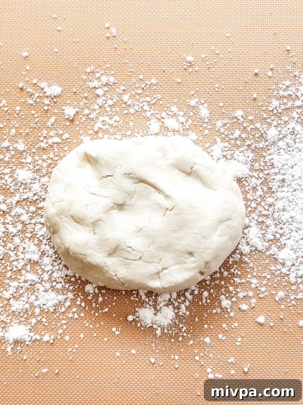 Peppermint patty dough placed on a silpat mat sprinkled with powdered sugar, ready for rolling.