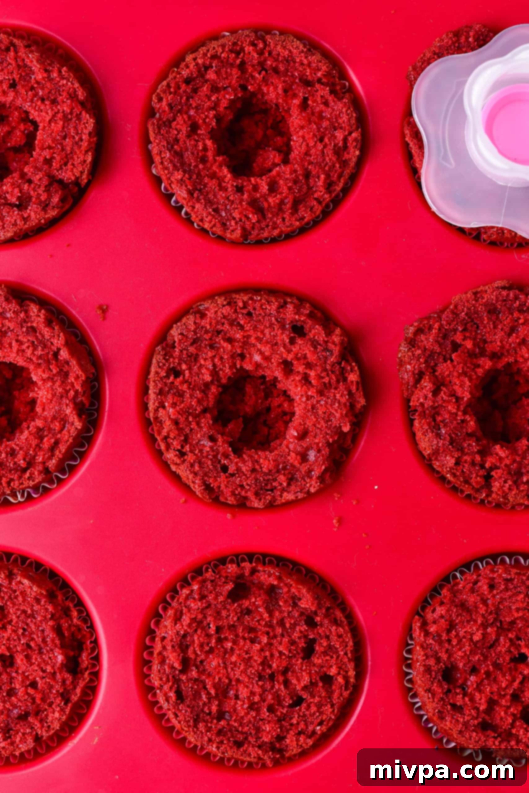 Red velvet cupcakes with a hole in the middle.