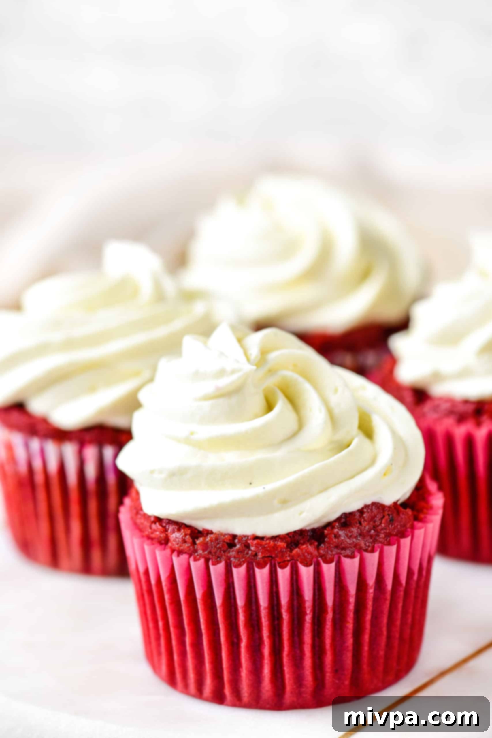 Up close shot of a red velvet cupcake with frosting.