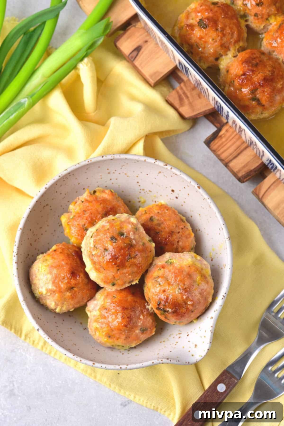 Top down view of a bowl of gluten-free chicken meatballs on yellow napkin.
