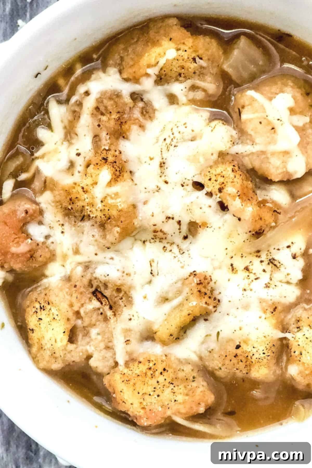 Top down view of crouton-topped French onion soup.