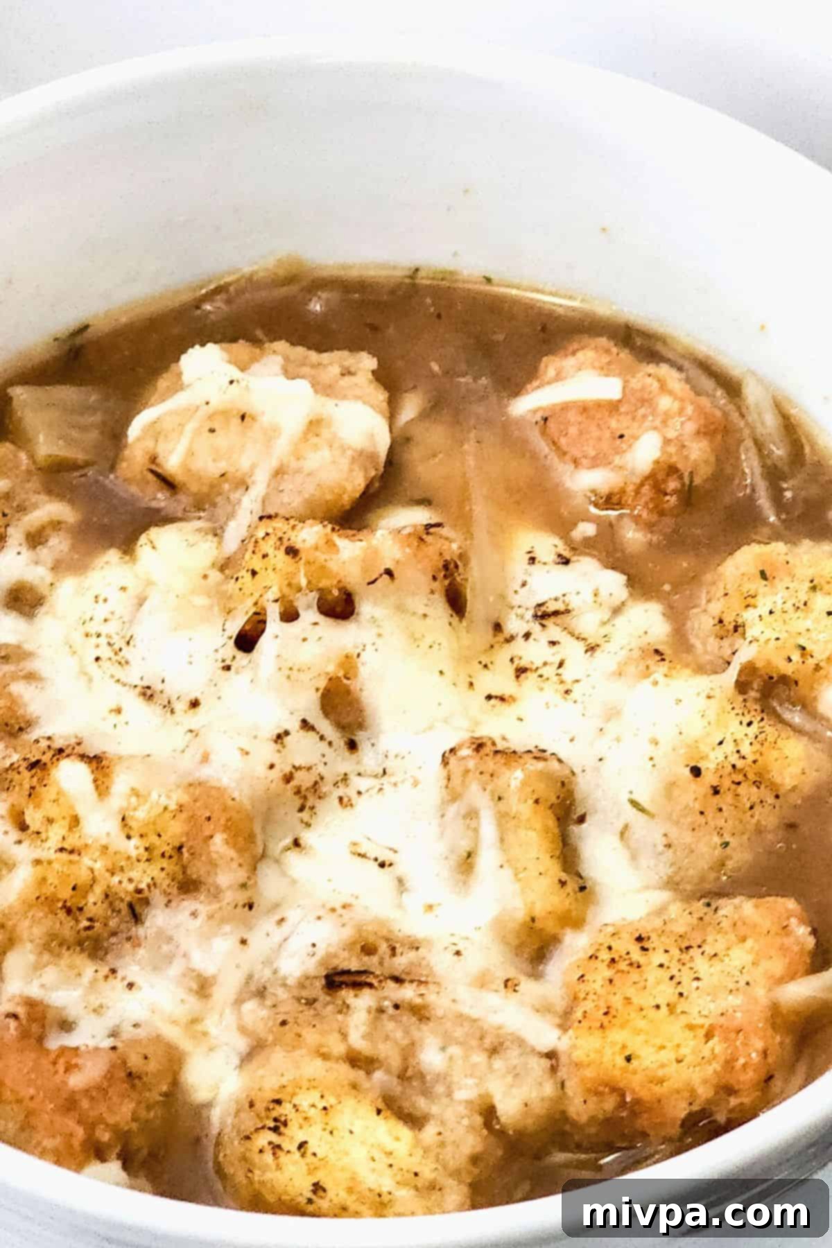 Up close shot of gluten-free French onion soup in a bowl.