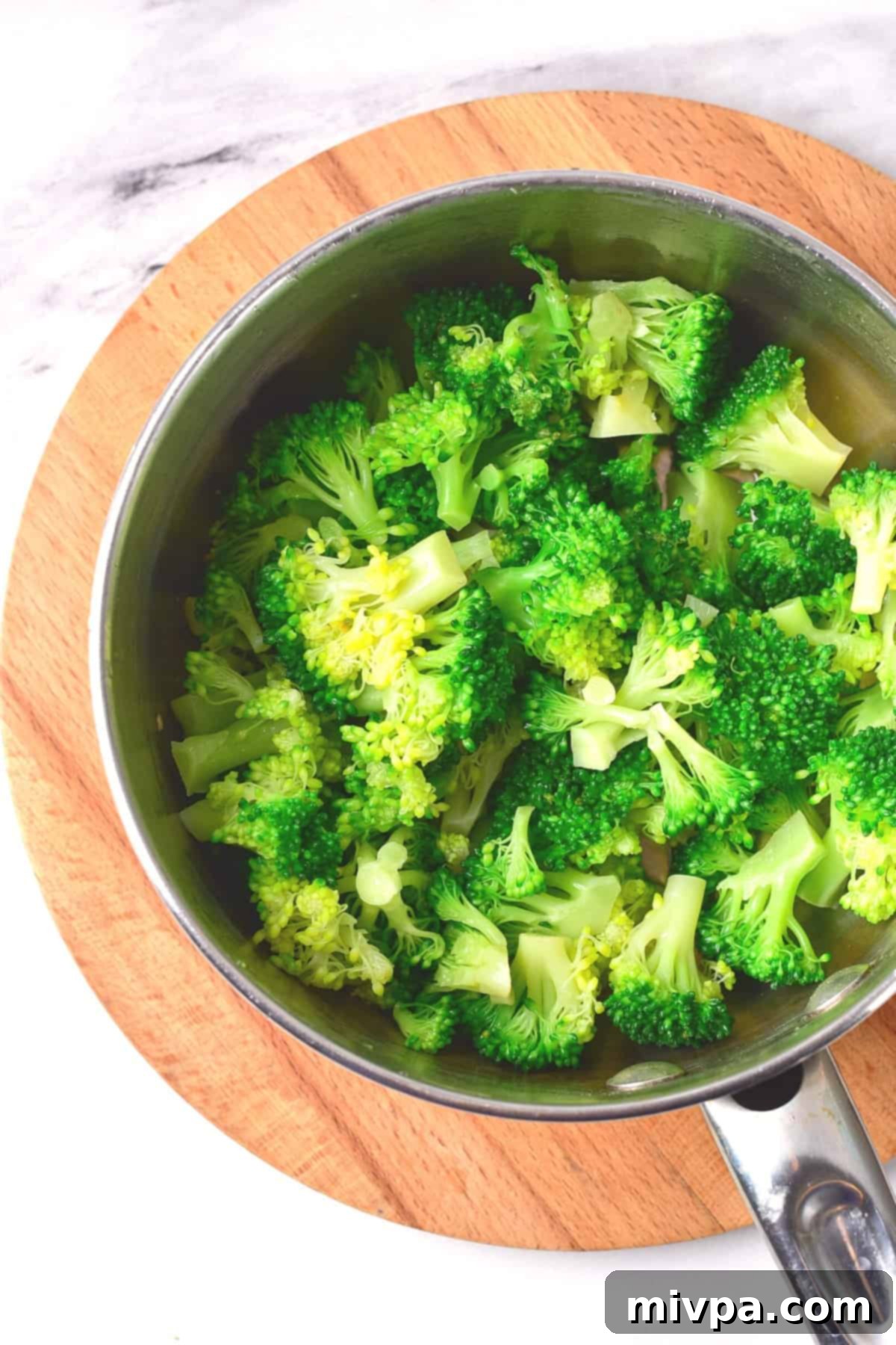 Gluten-Free Chicken Casserole (Dairy-Free) Blanched broccoli florets in a metal pot, showcasing their bright green color after cooking.