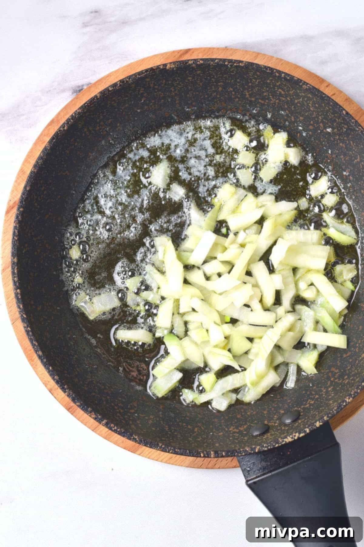 Gluten-Free Chicken Casserole (Dairy-Free) Sautéing diced onions in a large skillet until translucent, releasing their sweet aroma.
