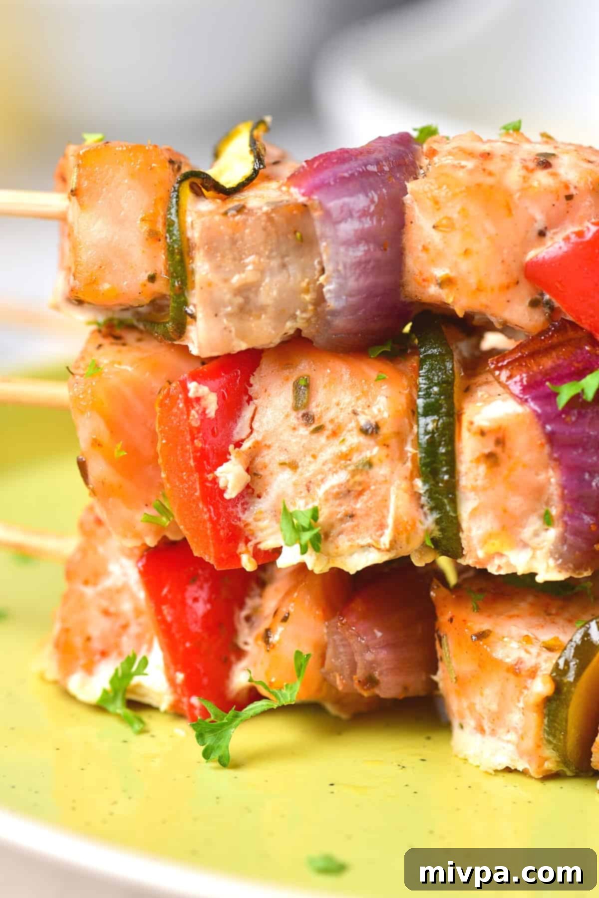Easy Salmon Kabobs (Gluten-Free, Dairy-Free) Up close view of salmon kabobs stacked on top of each other.