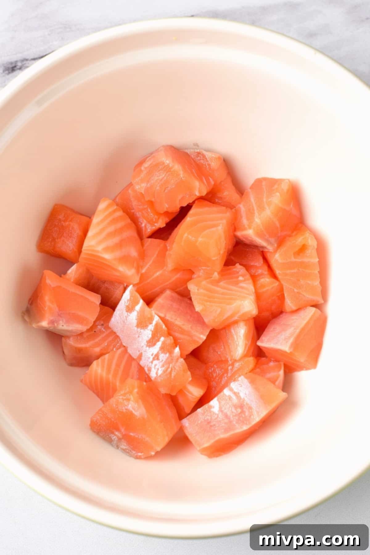 Salmon Kabobs Recipe (Gluten-Free, Dairy-Free) Salmon cubes in a white bowl.