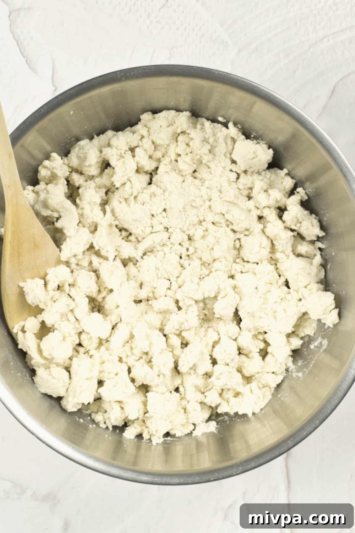 Mixing a dough in a metal bowl.
