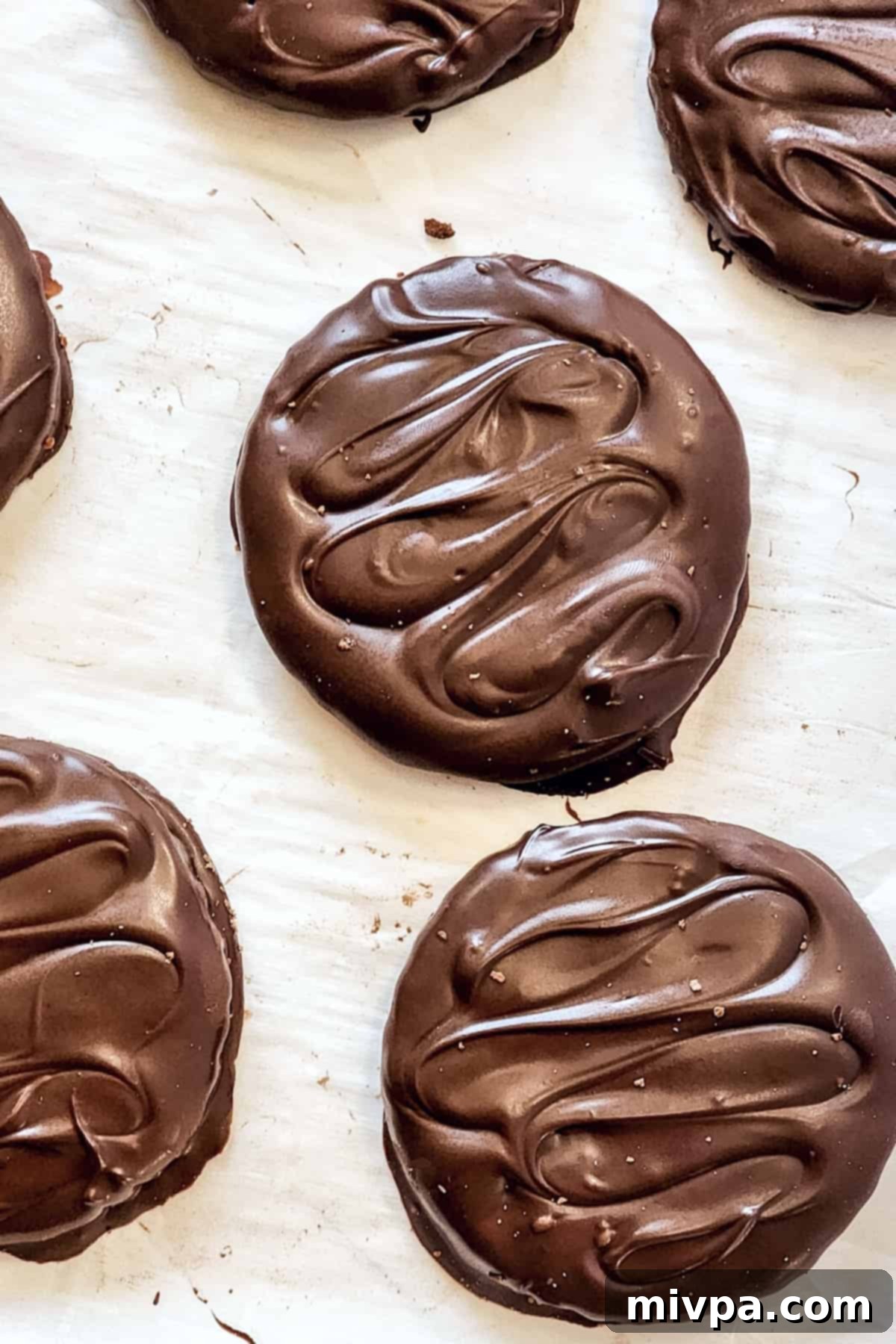 Homemade copycat Thin Mints on parchment paper.