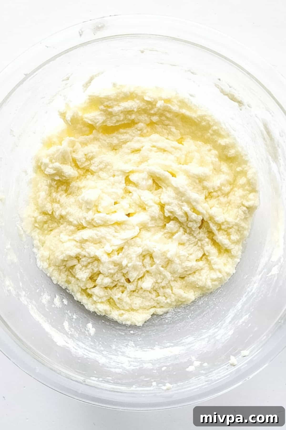 Creamed butter and sugar mixture in mixing bowl.