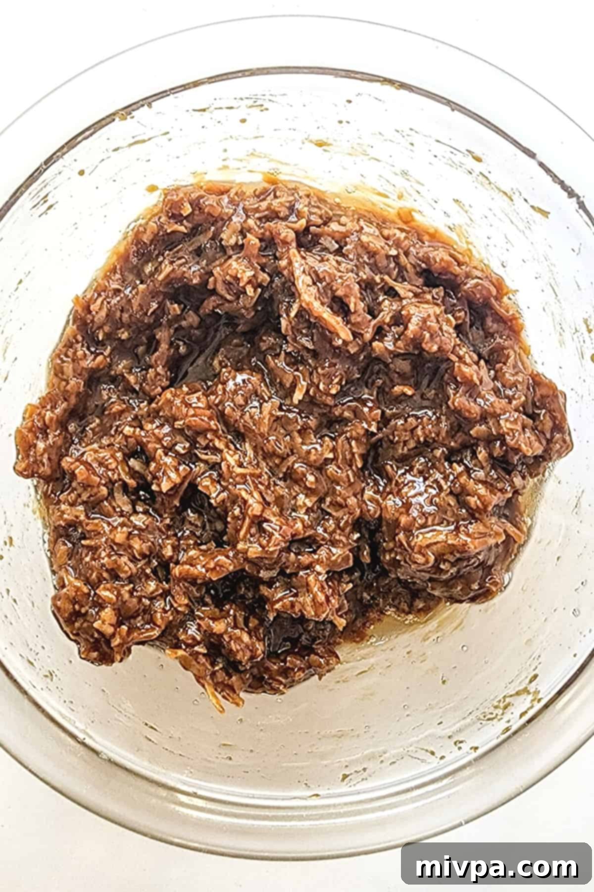 Gluten-Free Samoas Cookies (Dairy-Free) Coconut caramel mixture in glass bowl.