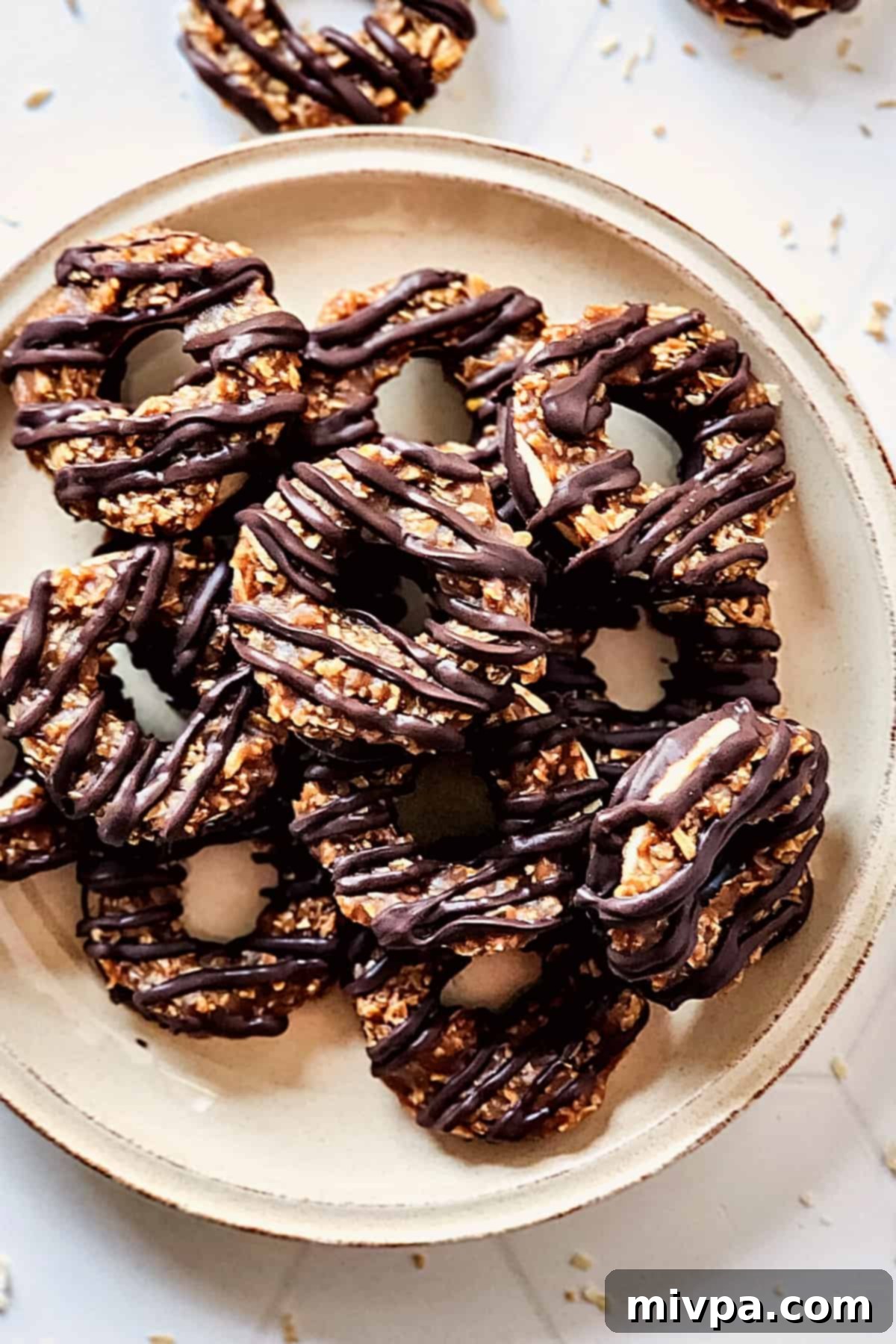 Gluten-Free Samoas Cookies (Dairy-Free) A plate of homemade samoas on white board.