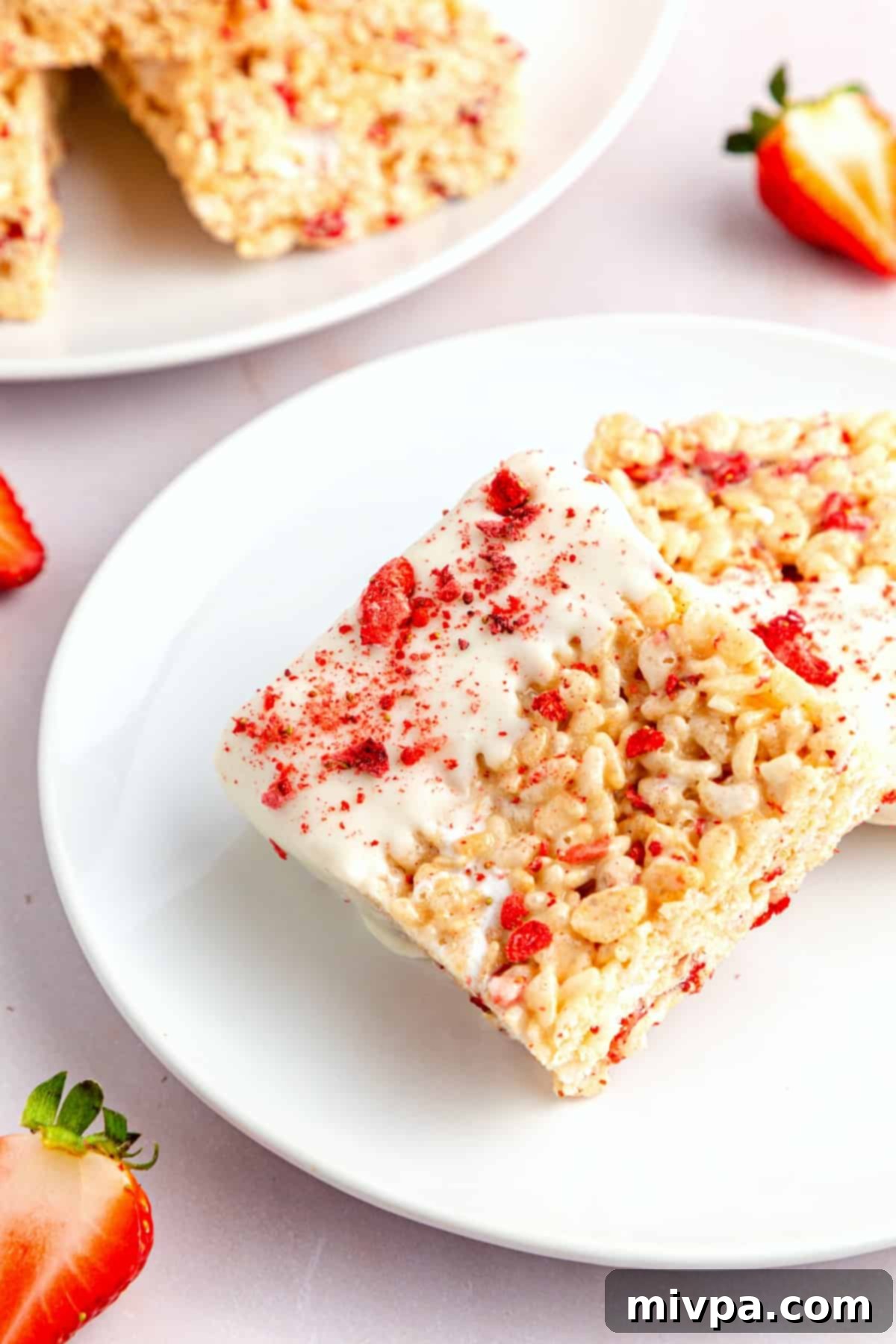 Up close shot of gluten-free strawberry rice Krispy treats on white plate, some dipped.