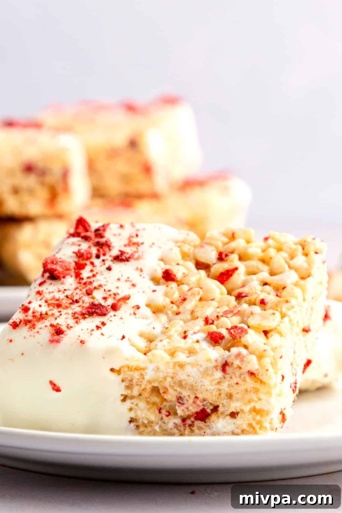 Up close shot of white chocolate-dipped strawberry rice krispies treats, showing the texture.