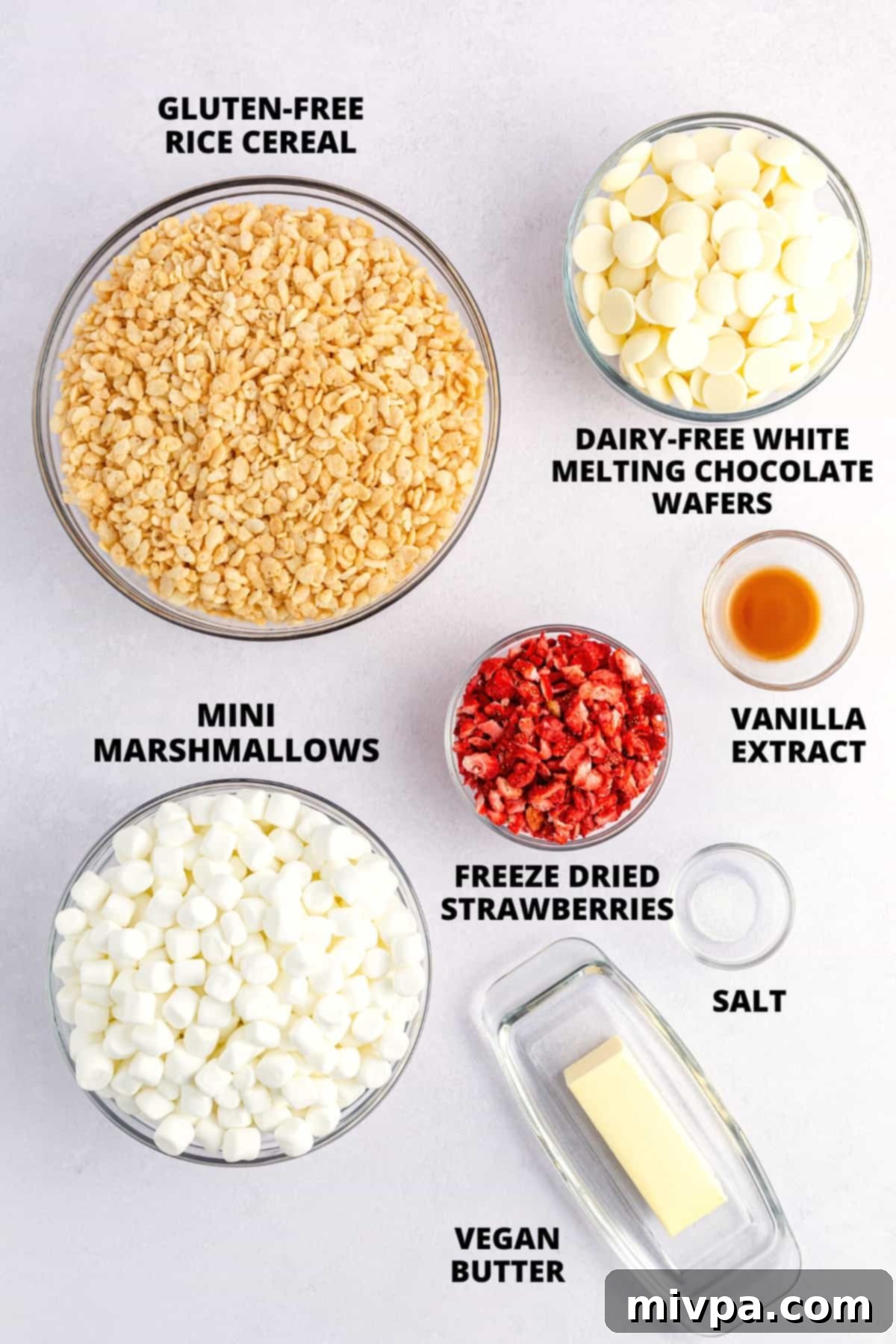 Ingredients for making gluten-free rice krispies treats recipe laid out on a white board.