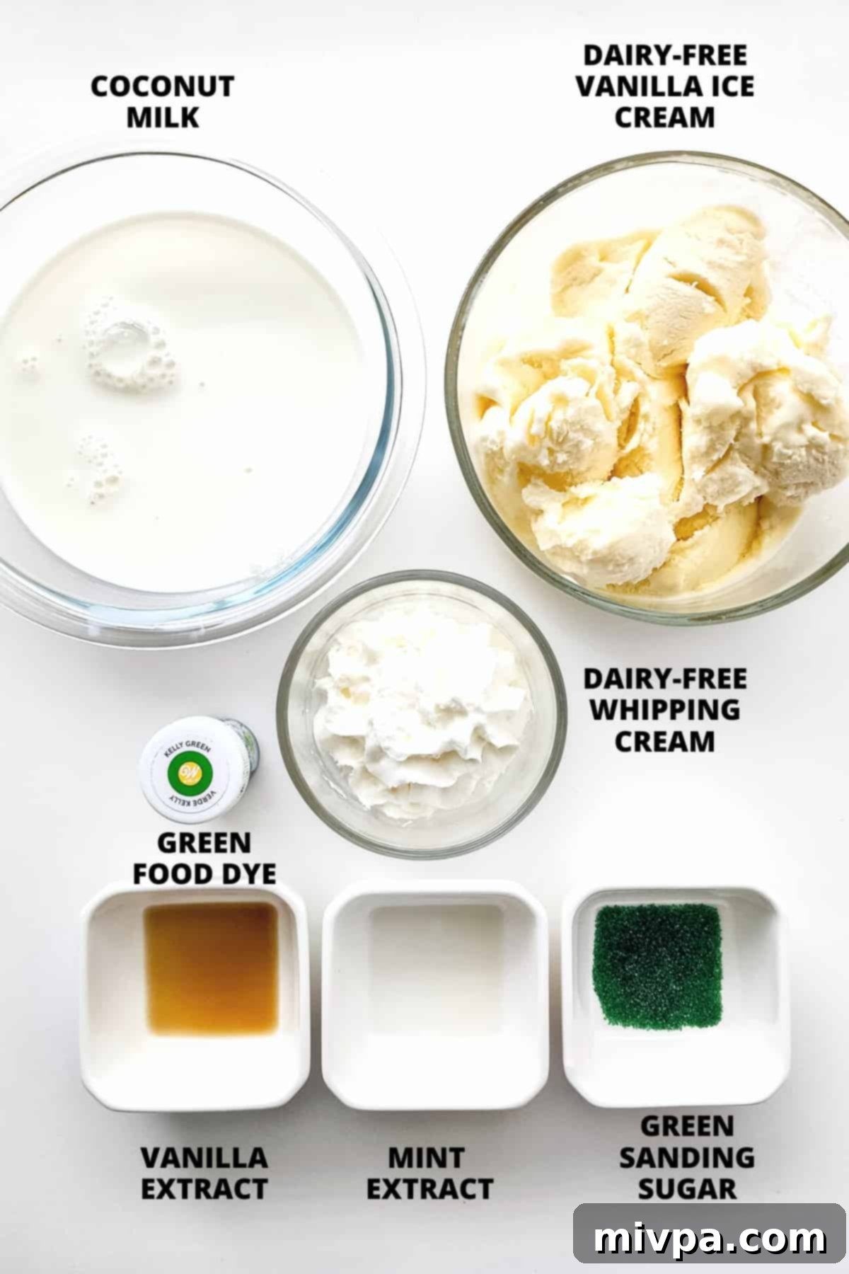 Homemade Vegan Shamrock Shake Recipe (Gluten-Free) All the ingredients for the vegan shamrock shake laid out neatly on a white background: vanilla ice cream, coconut milk, vanilla extract, mint extract, and green food dye.