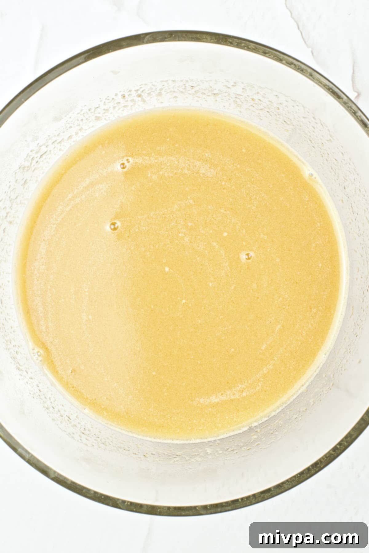 Warm milk, butter, and brown sugar mixture in a glass bowl.