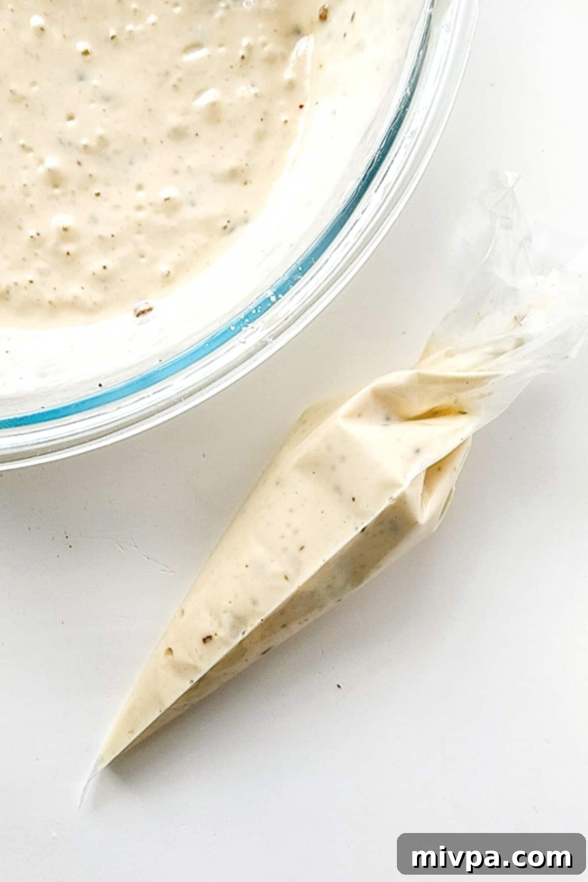 Gluten-free funnel cake batter neatly transferred into a piping bag.