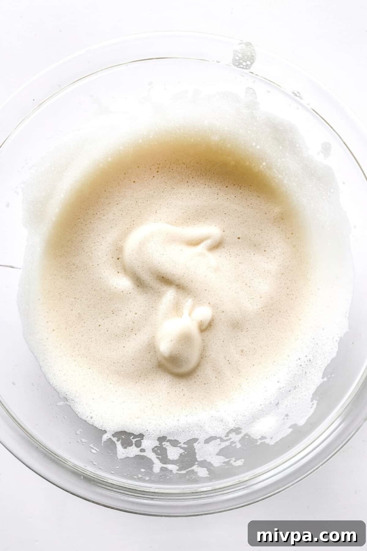 Beautifully whipped egg white mixture in a glass bowl.