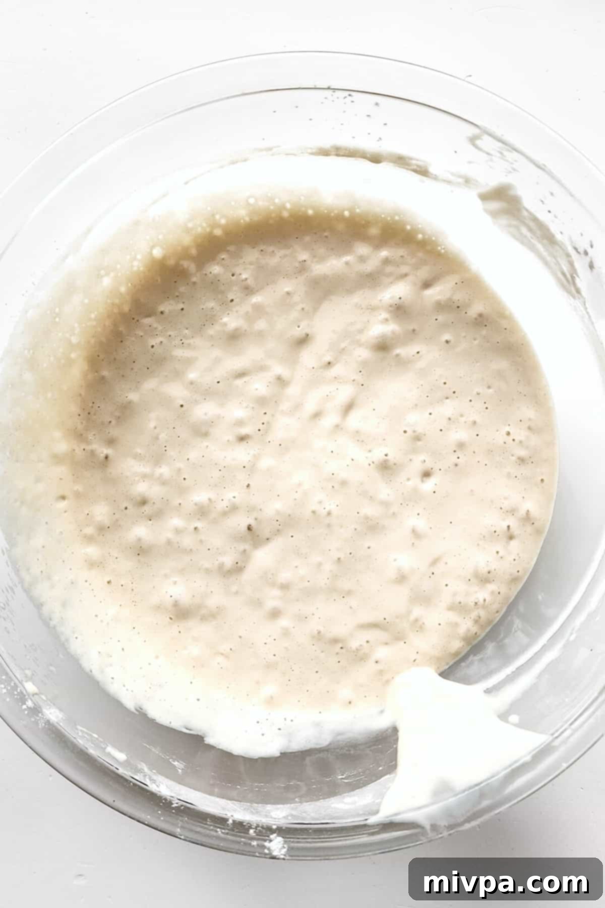 Smooth, prepared gluten-free funnel cake batter in a bowl, ready for piping.