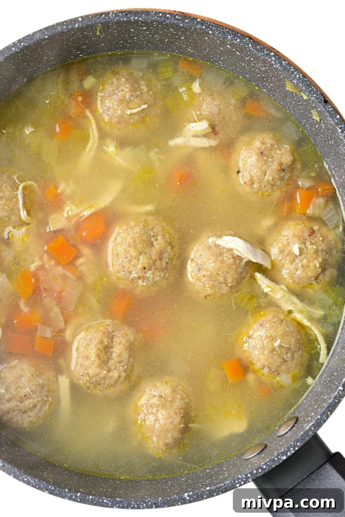 Gluten-Free Matzoh Ball Soup (Dairy-Free) - Cooking Matzo Balls Gluten-free matzo balls cooking and expanding in a bubbling chicken broth in a saucepan.