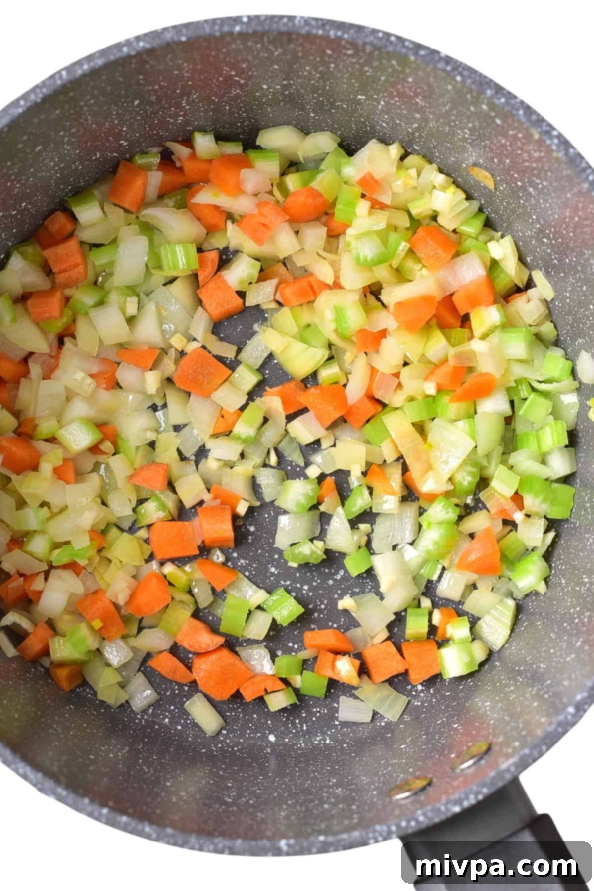 Homemade Matzo Ball Soup Recipe (Gluten-Free, Dairy-Free) - Sautéing Veggies Diced onions, carrots, celery, and minced garlic sautéing in olive oil in a skillet.