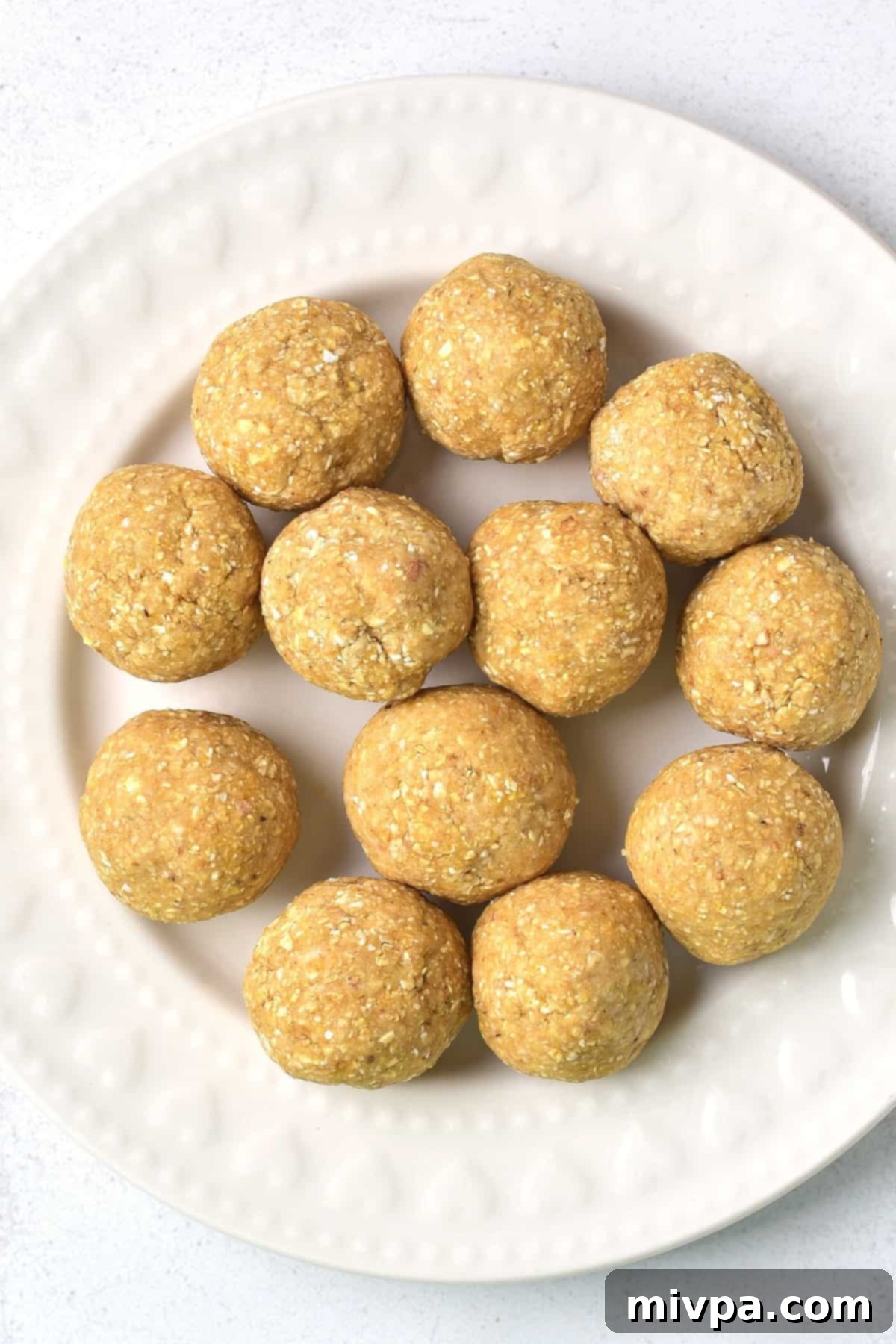 Homemade Gluten-Free Matzo Balls (Dairy-Free) - Shaped Neatly formed homemade gluten-free matzah balls arranged on a round white plate.