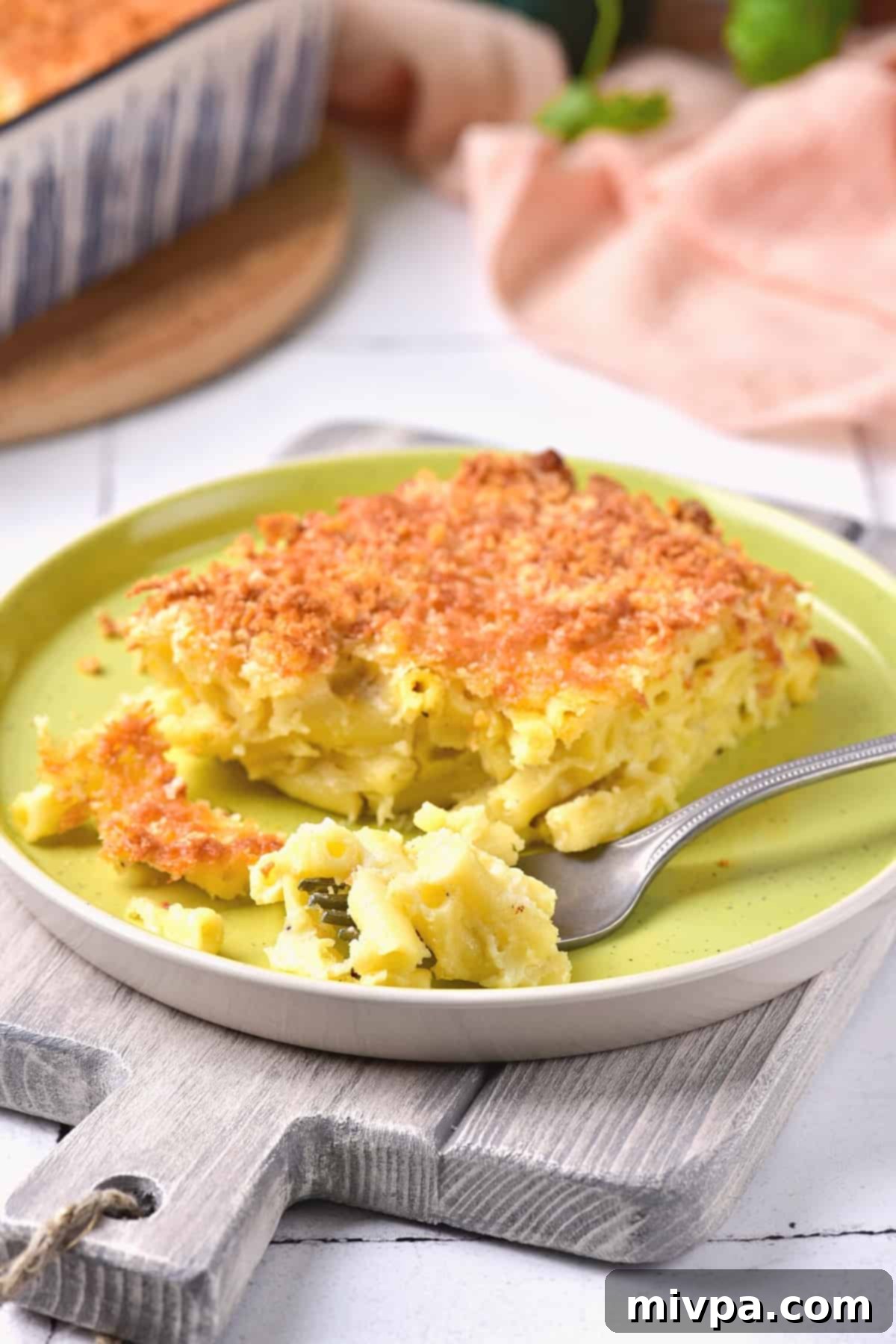 Fork on a plate with a half-eaten portion of macaroni and cheese.
