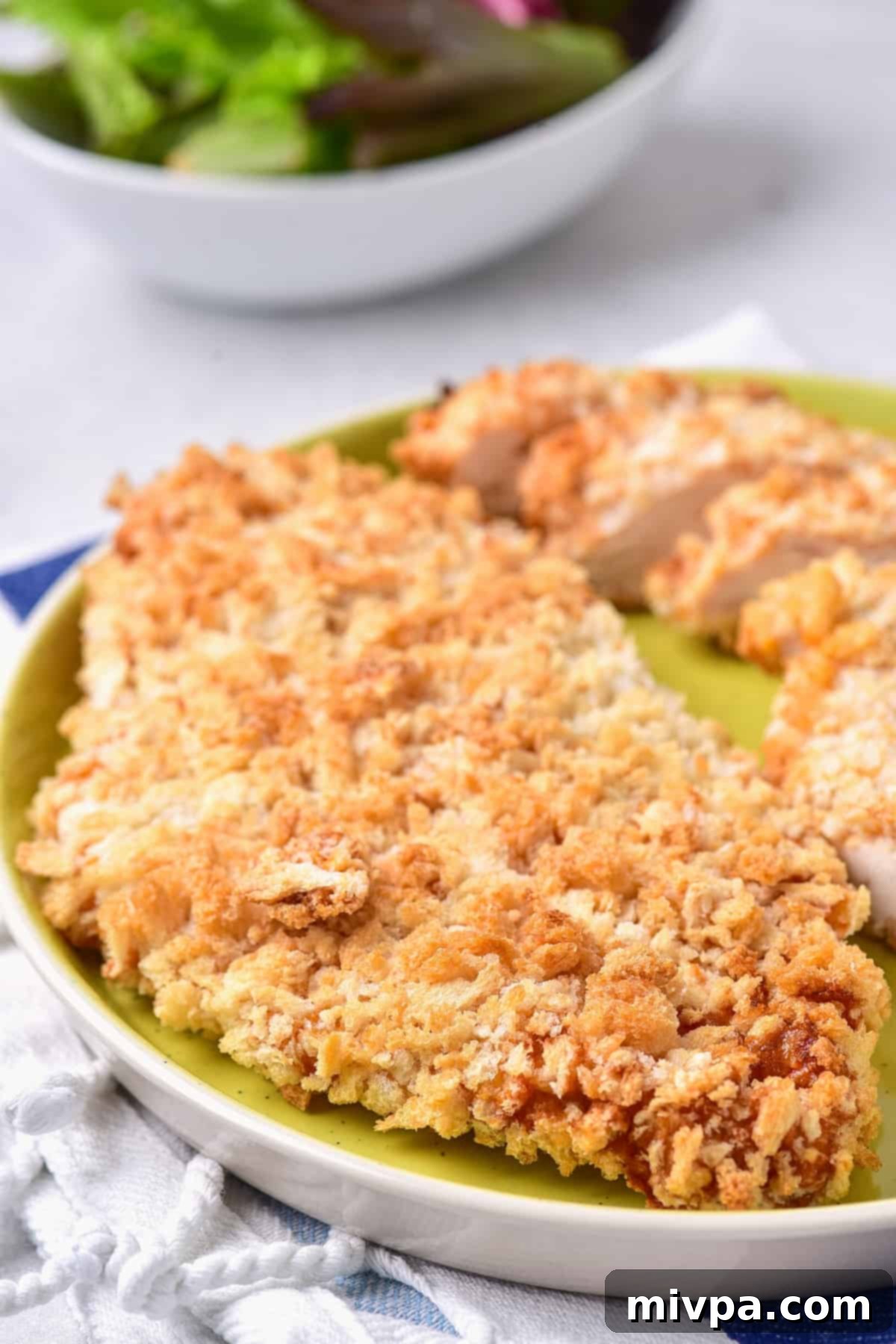 Crispy air fried chicken cutlets on green plate.