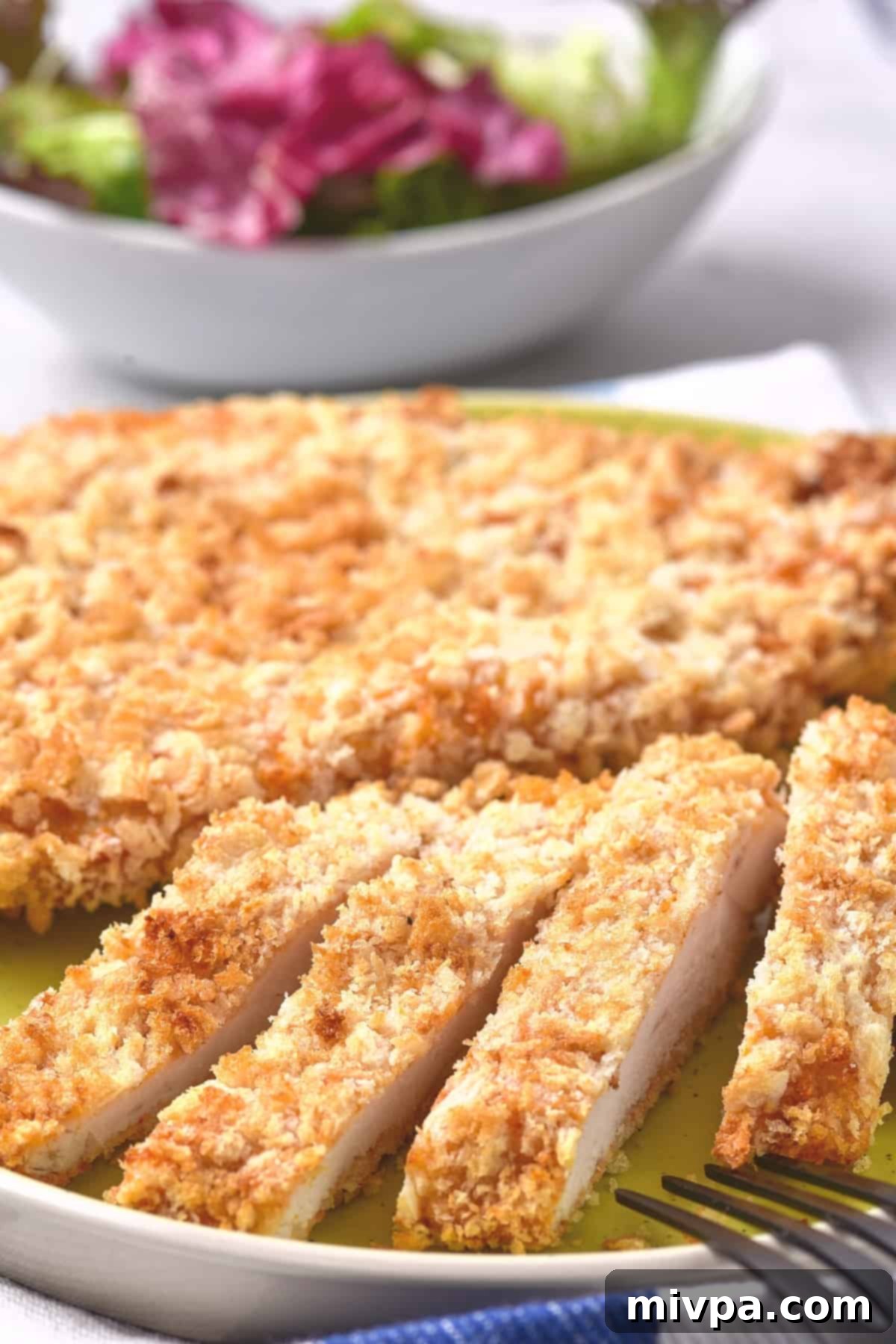Sliced chicken cutlets on a plate.