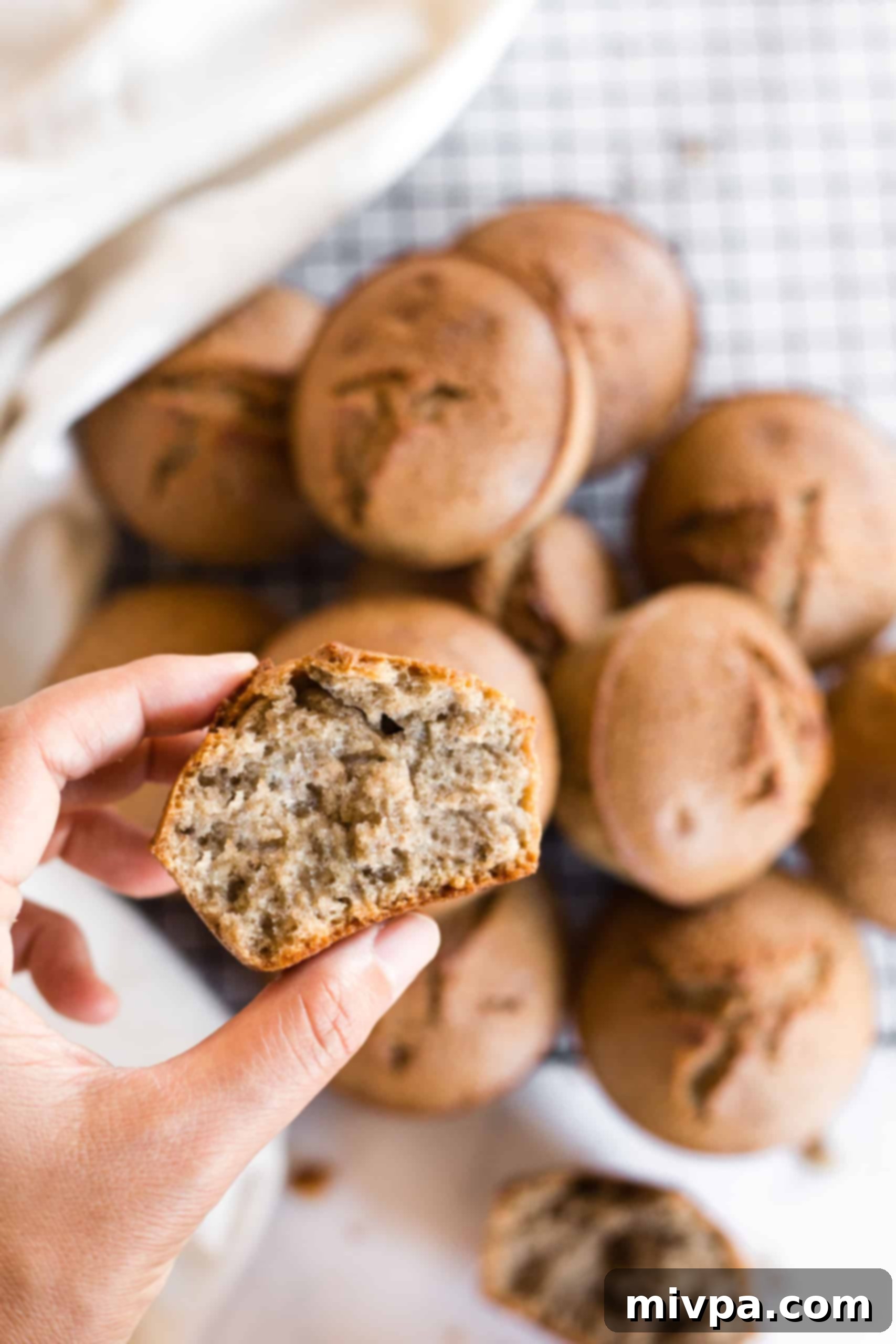 Holding up a half-eaten buckwheat muffin to show its perfectly tender and moist texture.
