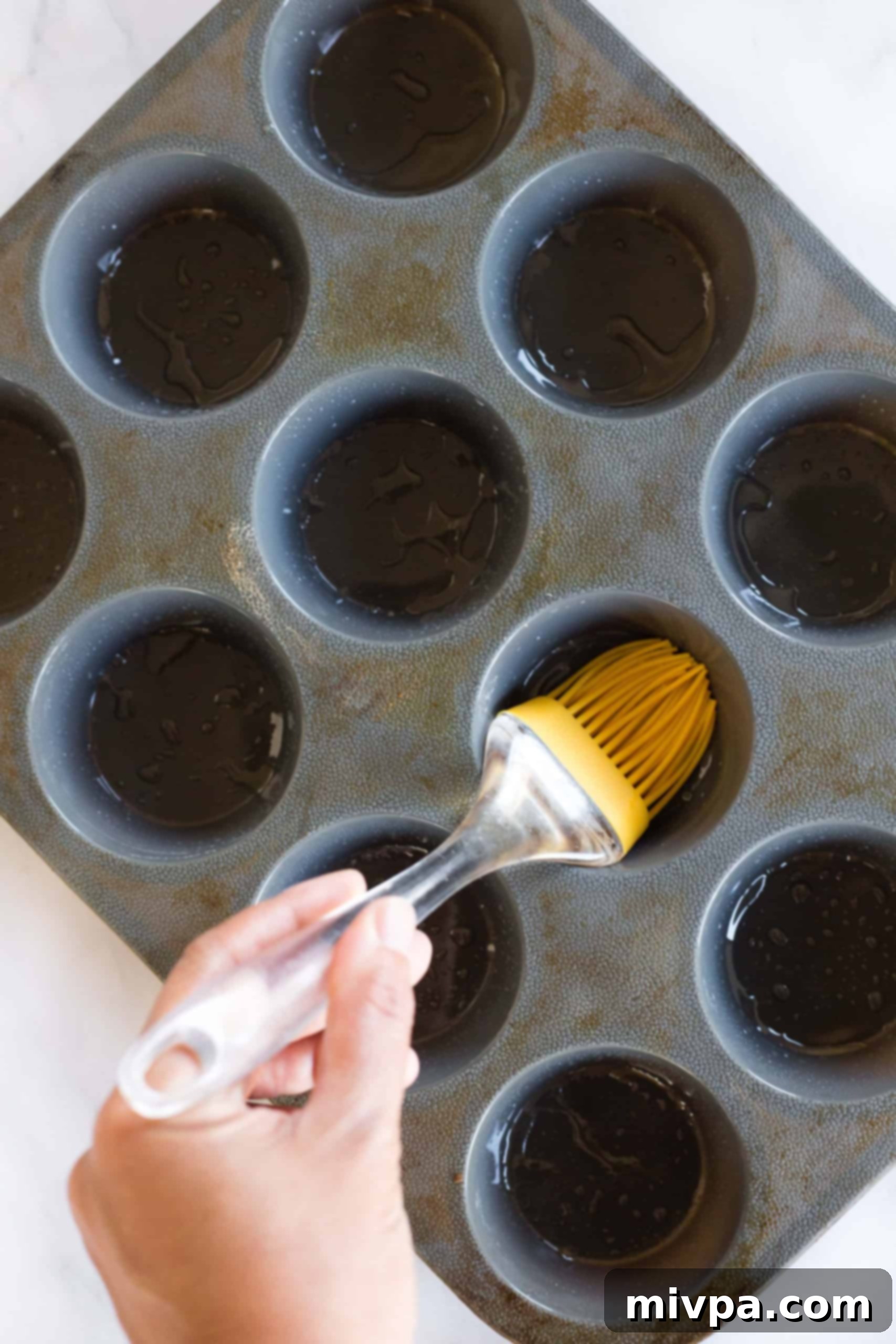Easy Buckwheat Muffins (Gluten-Free, Dairy-Free) Using a silicon brush to grease muffin mold cavities thoroughly.
