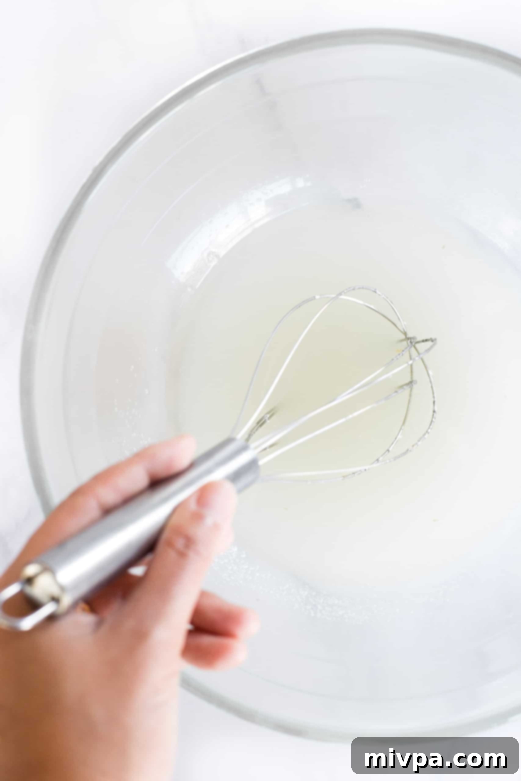 Mixing coconut oil and sugar together in a glass bowl until well combined.
