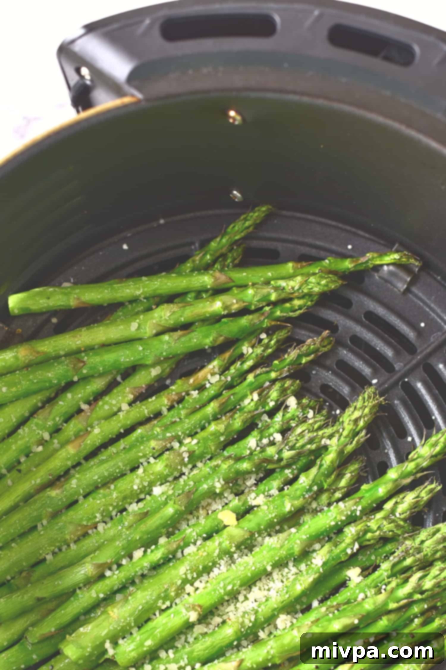 Perfectly air-fried asparagus spears sprinkled with dairy-free parmesan cheese, golden and ready.