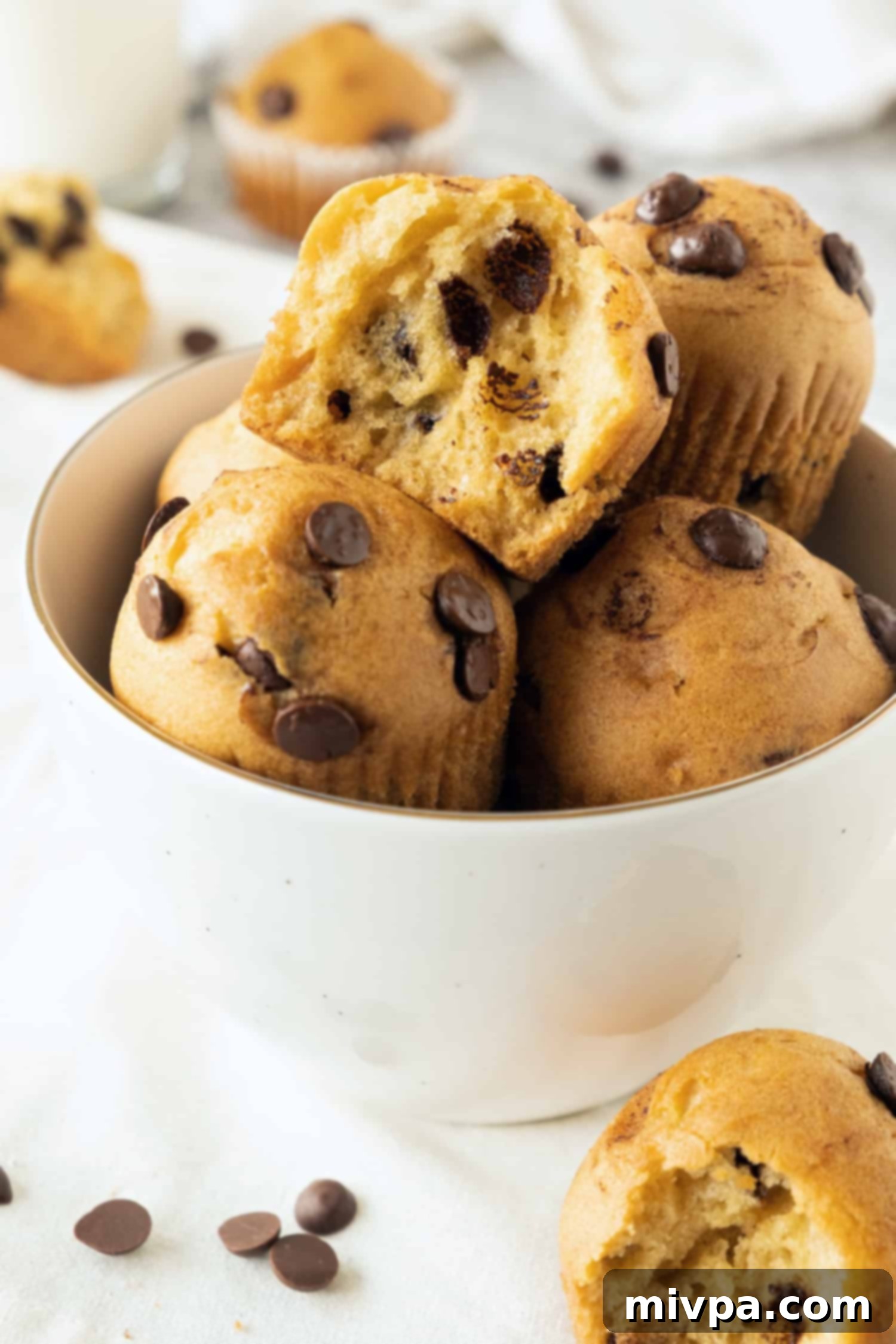 Gluten Free Chocolate Chip Muffins (Dairy-Free) A large bowl filled with an abundance of freshly baked gluten-free chocolate chip muffins, ready to be devoured.