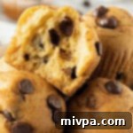 Gluten Free and Dairy Free Chocolate Chip Muffins 2 Up close shot of a half-eaten chocolate chip muffin, showing its soft interior and melted chocolate.