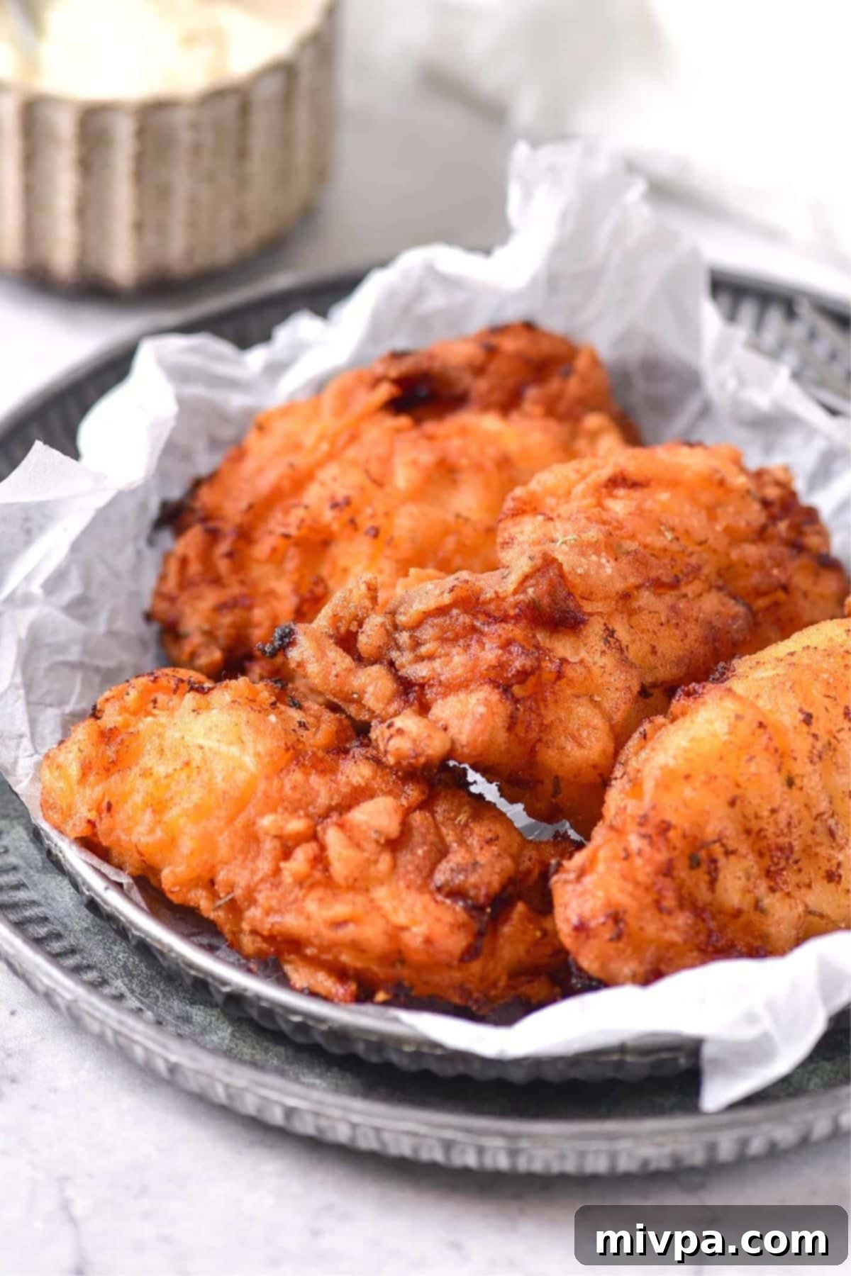 Gluten-Free Dairy-Free Fried Chicken Recipe A selection of gluten-free dairy-free fried chicken pieces arranged on parchment-lined plates, garnished with fresh herbs.
