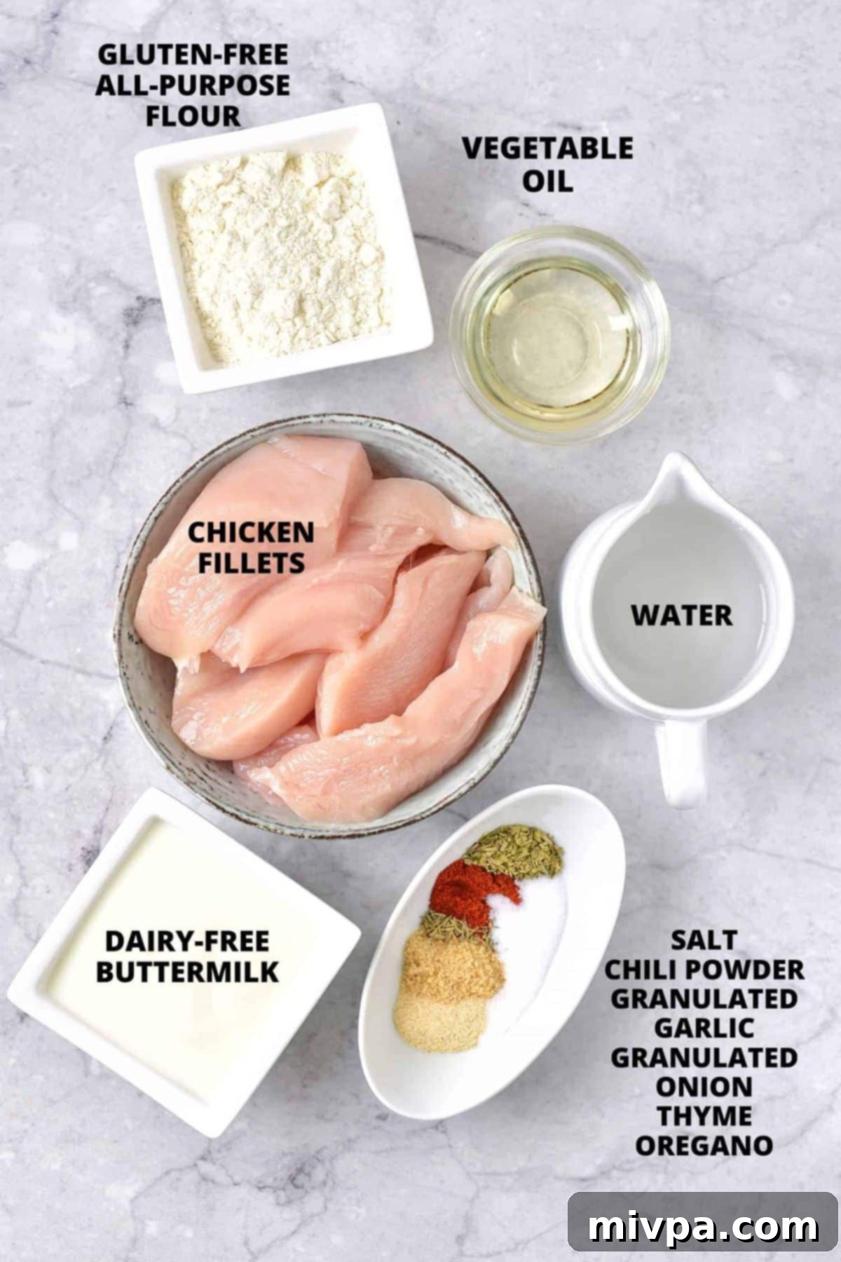 Gluten-Free Dairy-Free Fried Chicken All the ingredients for the gluten-free fried chicken recipe carefully laid out on a stylish marble board.