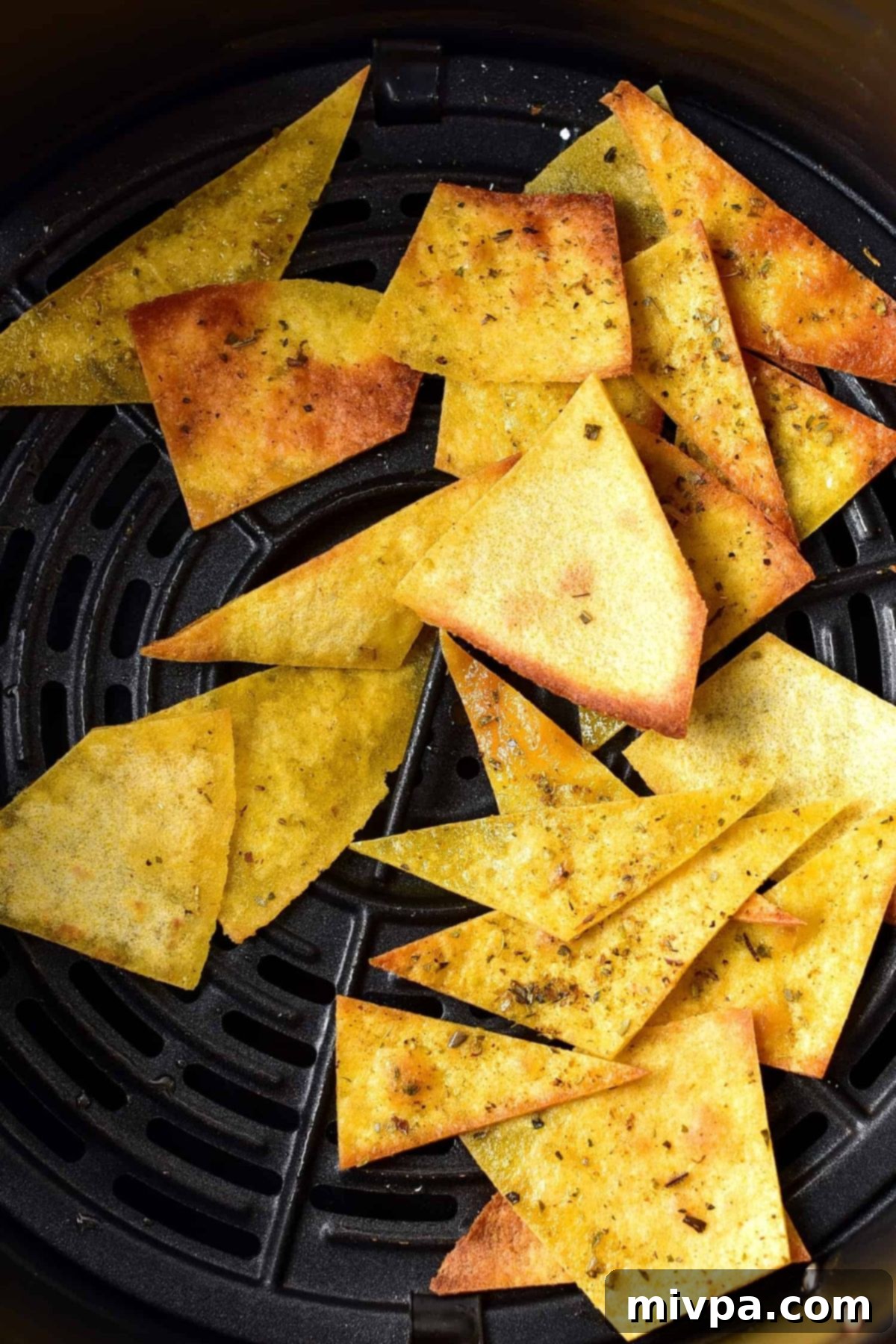 Homemade tortilla chips in air fryer basket.