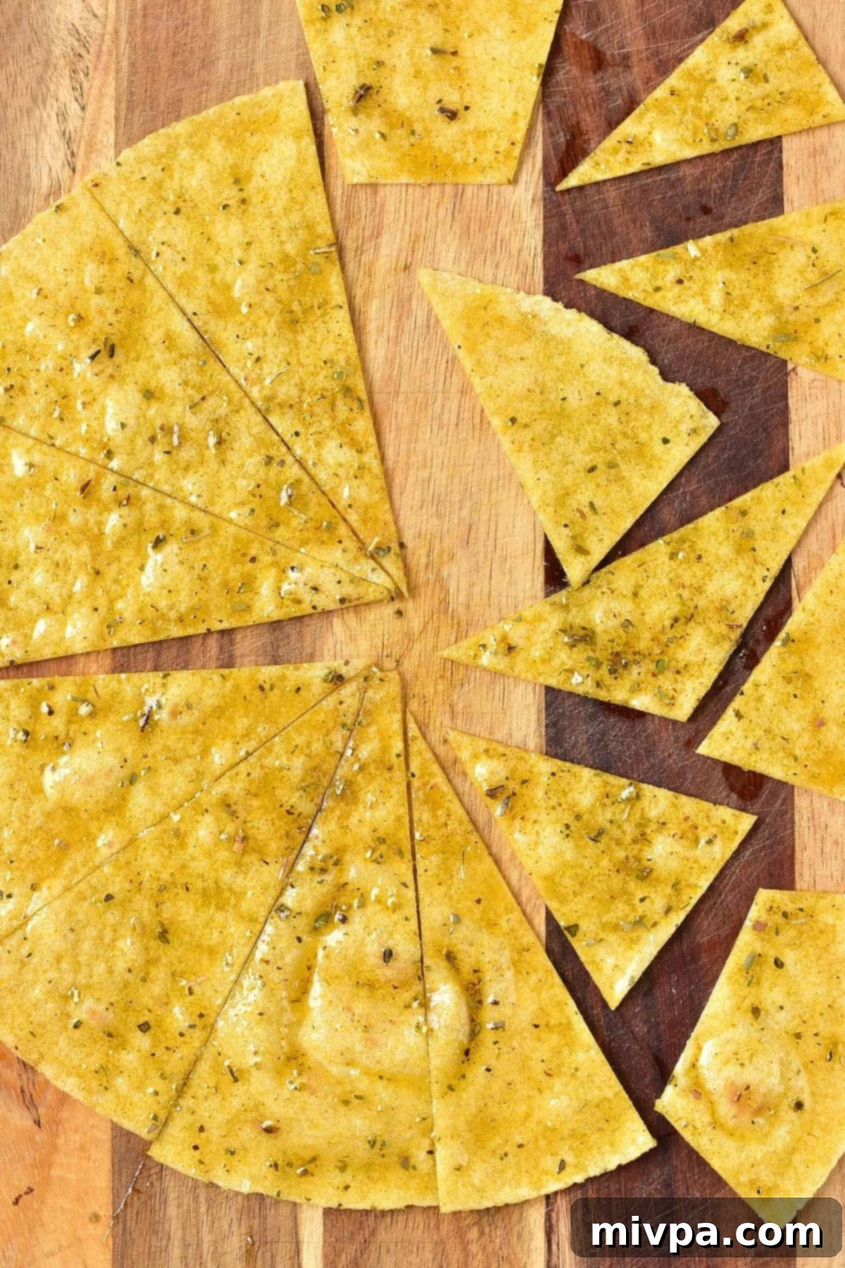 Sliced corn tortilla pieces on wooden board.