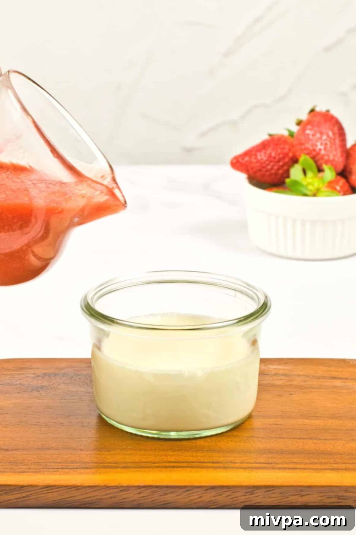 Vegan Panna Cotta (Gluten-Free, Dairy-Free) Pouring strawberry sauce over vegan panna cotta.
