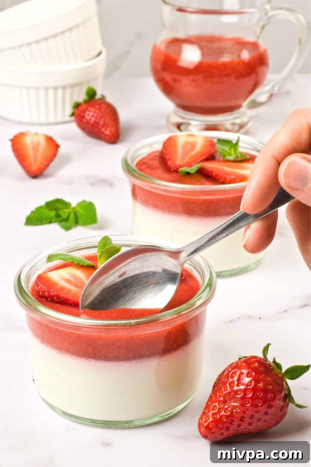 Gluten Free Panna Cotta (Vegan) Scooping into a bowl of strawberry-topped coconut milk panna cotta.