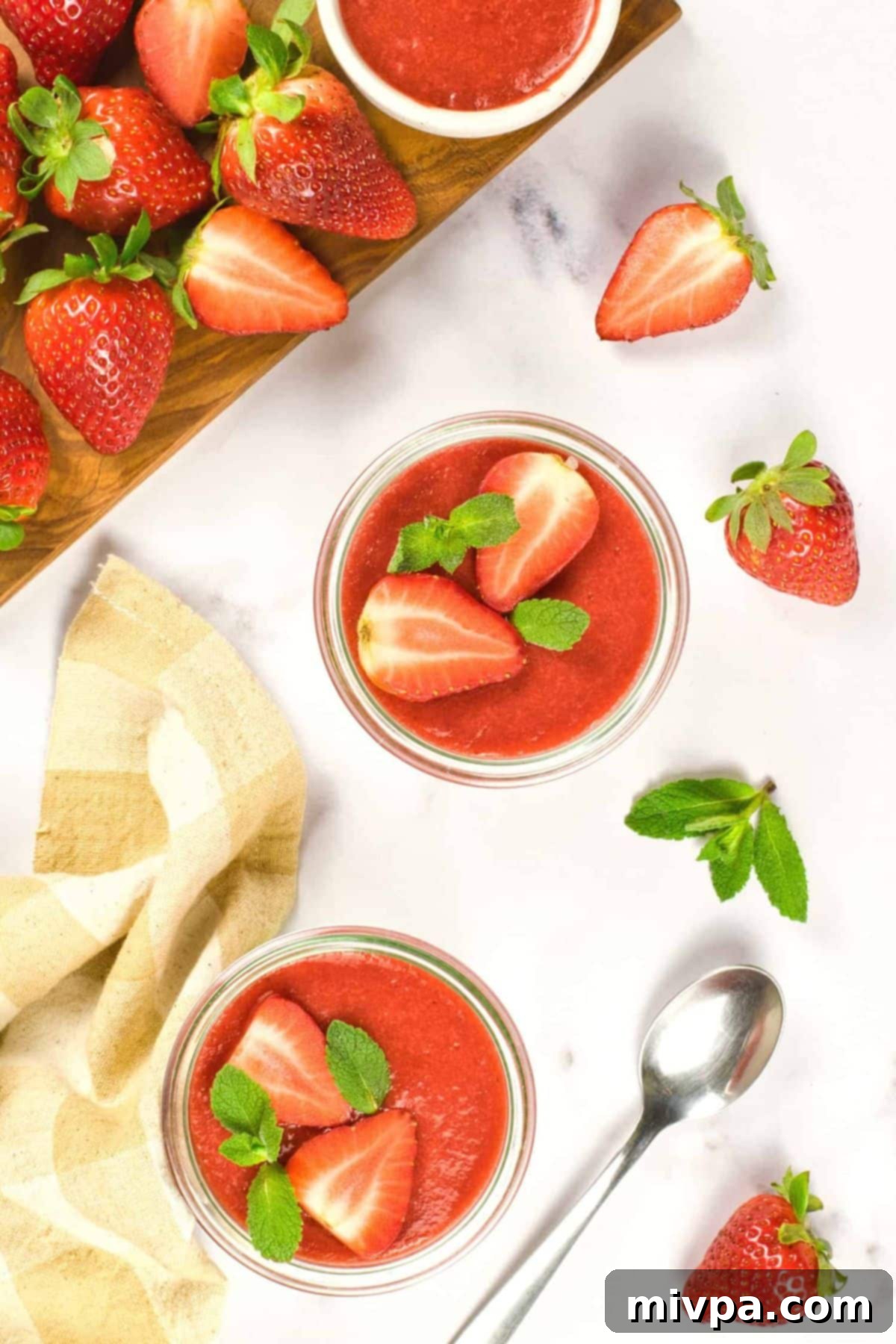 Easy Coconut Panna Cotta Recipe (Gluten-Free, Vegan) Top down view of jars of strawberry panna cotta on marble board.