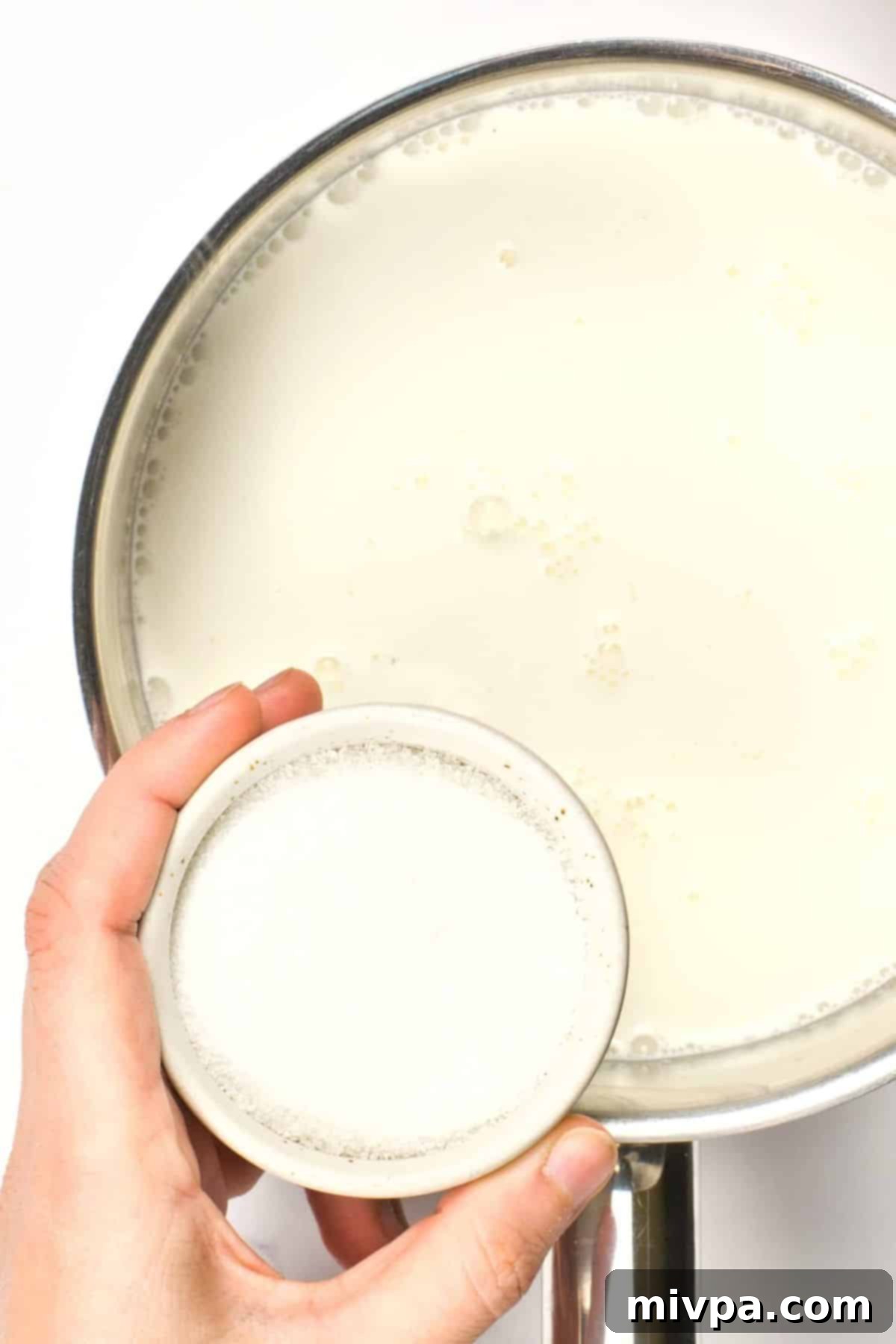 How to Make Panna Cotta with Coconut Milk (Vegan, Gluten-Free) Pouring sugar into a saucepan of coconut milk.