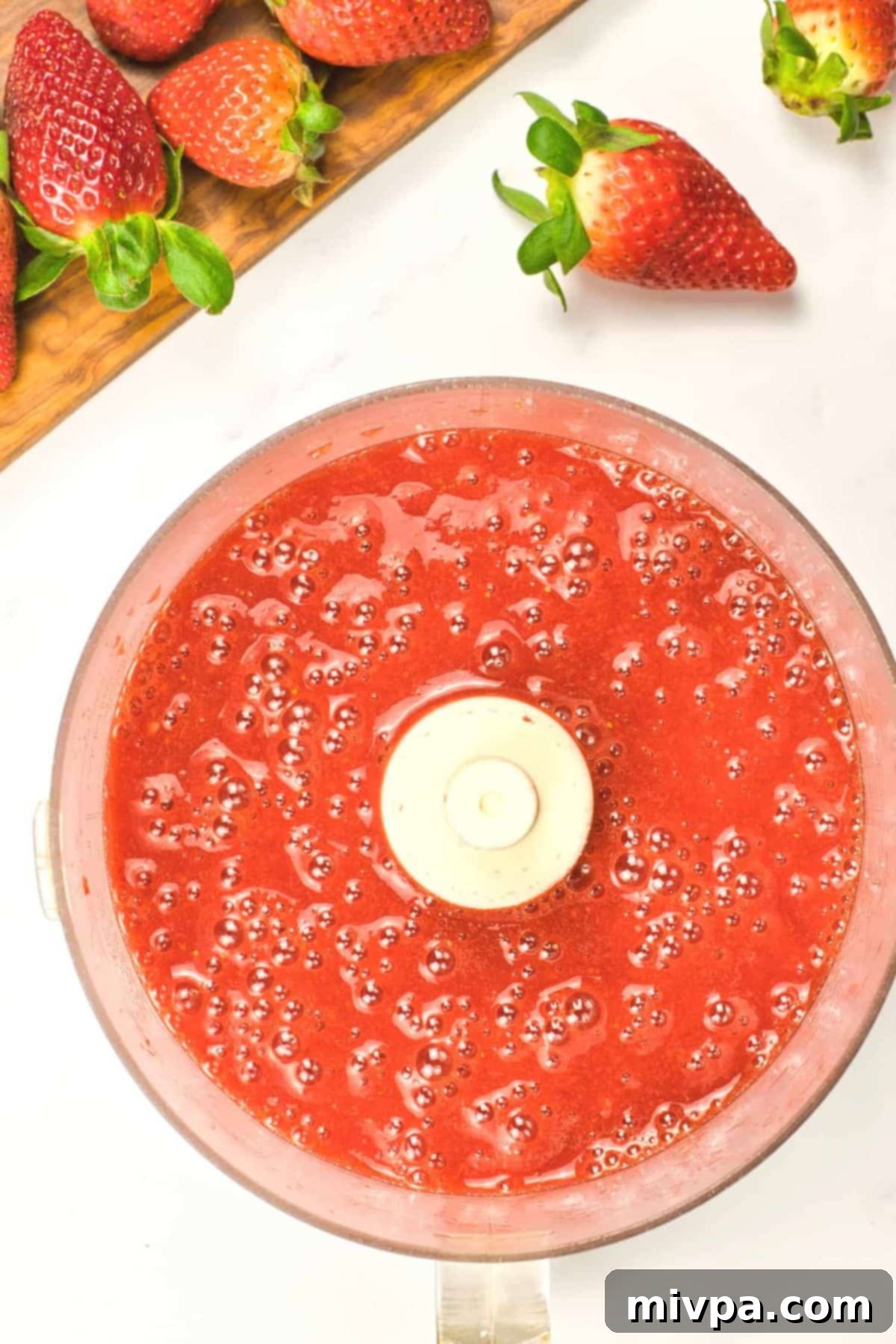 Vegan Coconut Panna Cotta (Gluten-Free) Top down view of strawberry liquid mixture in food processor.
