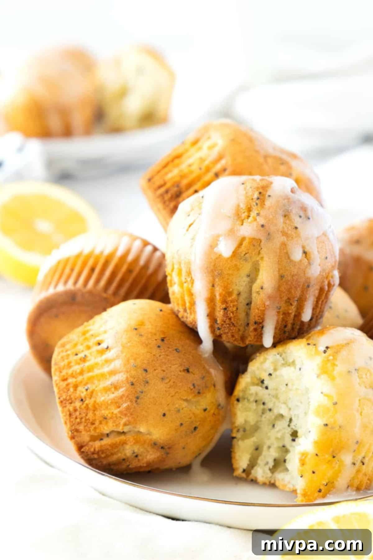 Gluten-Free Lemon Poppy Seed Muffins (Dairy-Free) A plate of fluffy, perfectly golden gluten-free lemon poppy seed muffins, drizzled with a bright lemon glaze.