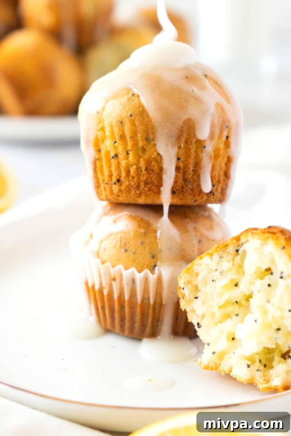Gluten-Free Lemon Poppy Seed Muffins (Dairy-Free) Several glazed lemon poppy seed muffins arranged on a plate, showing the beautifully set lemon icing.