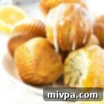 Zesty Lemon Poppy Seed Muffins Gluten Dairy Free 2 Half-eaten gf lemon poppy seed muffins on plate.