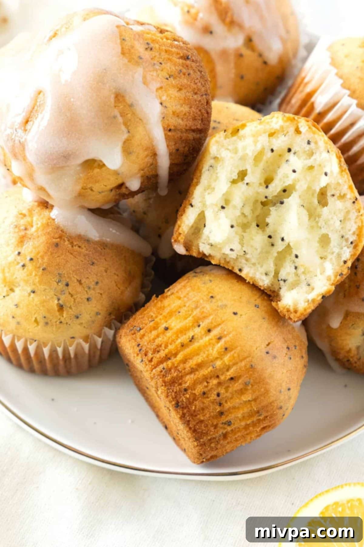 Gluten-Free Lemon Poppyseed Muffins (Dairy-Free) A close-up shot of a half-eaten dairy-free lemon poppy seed muffin, revealing its moist texture and golden-brown exterior.